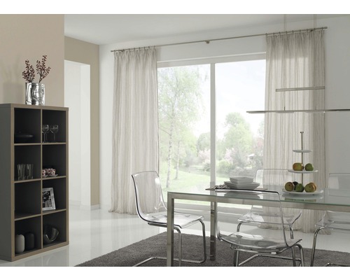 Svetlá jedáleň s priehľadnými stoličkami, stôl s kovovými nohami, regál a závesy