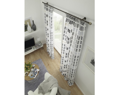 Obývacia izba so závesmi s geometrickým vzorom na záclonovej tyči