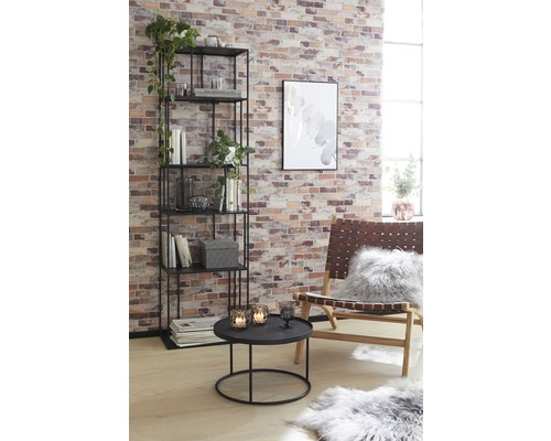 Obývacia izba s regálom, stolom a kreslom pred tehlovou stenou