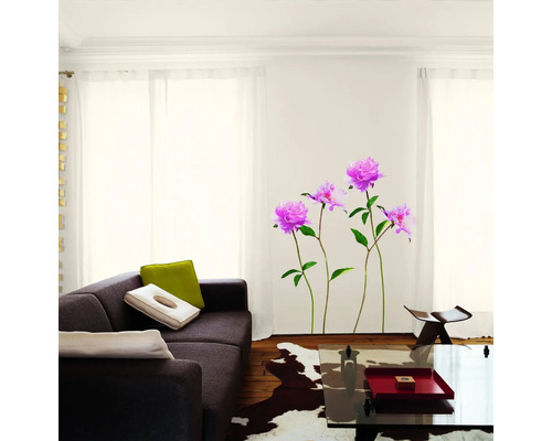 Obývacia izba s pohovkou, konferenčným stolíkom a nástennou nálepkou s kvetinovým motívom