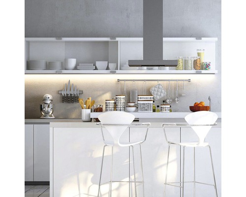 Svetlá kuchyňa s bielymi kuchynskými skrinkami, odsávačom pár a barovými stoličkami.