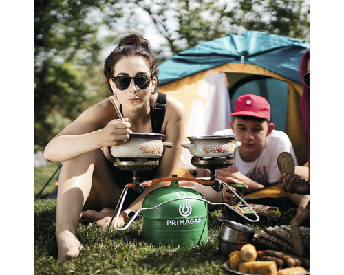 Kempingová scéna s ľuďmi, plynovým sporákom a kuchynským náčiním