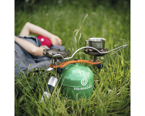 Plynový varič Primagas s hrncom v tráve