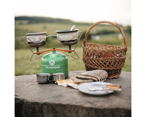 Piknik s plynovým varičom, riadom, chlebom a košíkom na stole