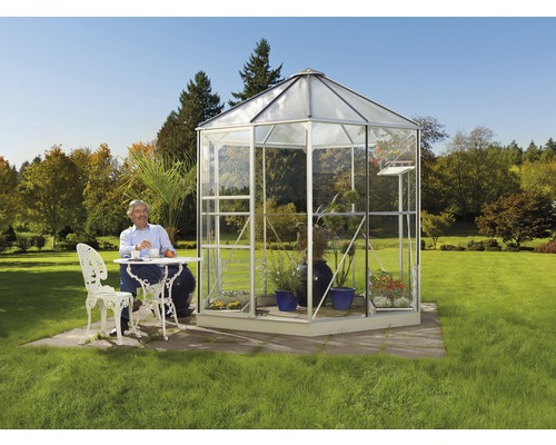 Voľne stojaci skleník so stolom a sediacim mužom