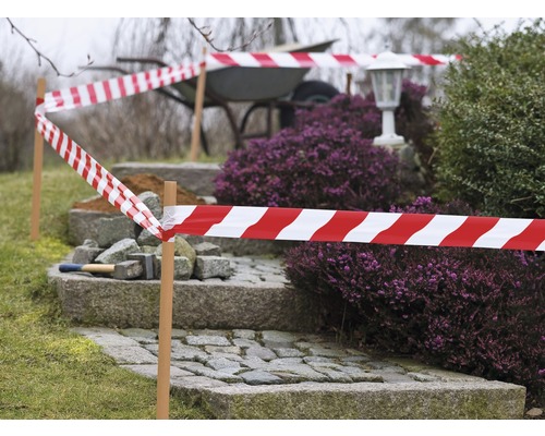 Ohradená záhrada s červeno-bielou výstražnou páskou a schody z dlažobných kociek