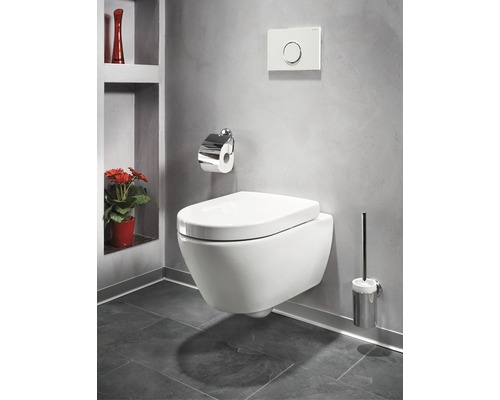 Závesné WC v kúpeľni s držiakom toaletného papiera, splachovacím tlačidlom a WC kefou