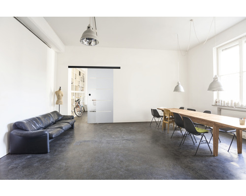 Svetlá izba s pohovkou, stolom, stoličkami a sklenenými posuvnými dverami