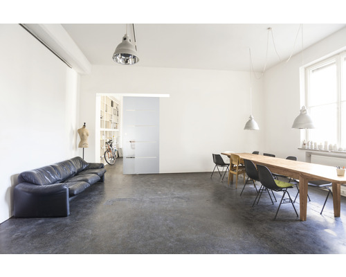 Interiérová fotografia svetlej miestnosti s pohovkou, jedálenským stolom a posuvnými dverami