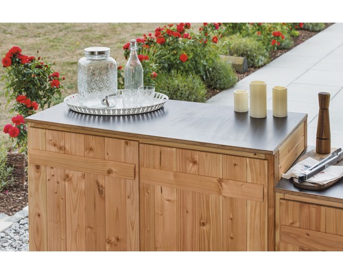 Záhradná skrinka s dreveným obkladom a doskou stola, zdobená dávkovačom nápojov, fľašou, pohármi, podnosom a sviečkami