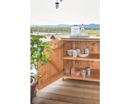 Drevená skrinka s riadom a pohármi vo vonkajšom prostredí.