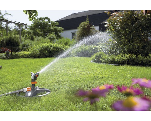 Záhradný zavlažovač zavlažuje trávnik v záhrade.