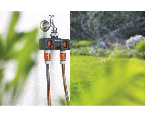 Rozdeľovač vody Gardena na vodovodnom kohútiku s dvoma pripojenými záhradnými hadicami.