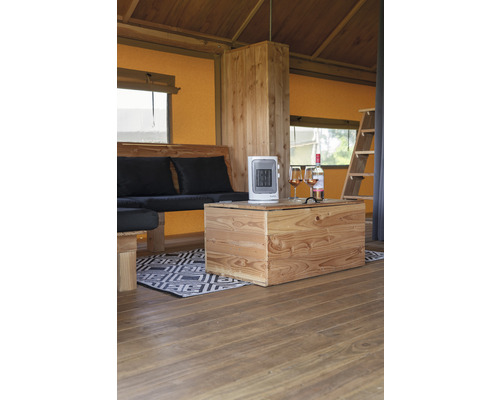 Interiér stanu s dreveným nábytkom, ohrievačom a nápojmi.