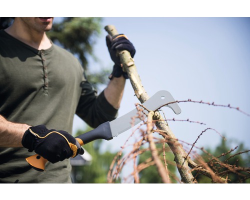 Muž reže konár s hákovou mačetou