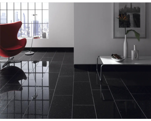 Obývacia izba s lesklými čiernymi podlahovými dlaždicami, kreslom, stolom a oknom