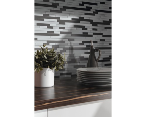 Stena z mozaikových dlaždíc nad kuchynskou linkou s riadom a dekoráciou