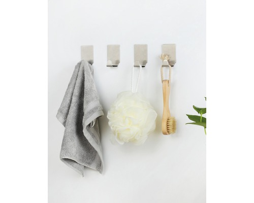 Štyri nástenné háčiky s uterákom, hubkou do kúpeľa a kefou na stene