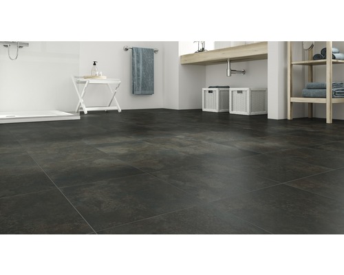 Kúpeľňa s tmavou dlažbou, umývadlom a sprchou.