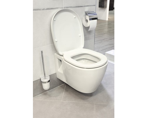 Závesné WC s otvoreným vekom, WC kefa a držiak papiera v kúpeľni.
