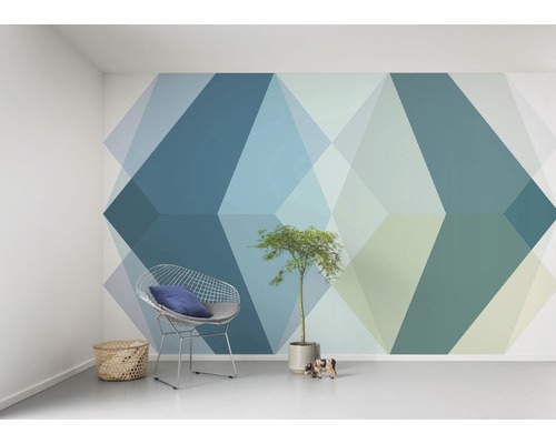 Obývacia izba s geometrickou tapetou, drôteným kreslom a izbovou rastlinou