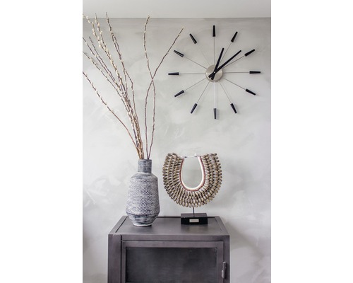 Dekoratívne zátišie s vázou, vetvami, šperkom a nástennými hodinami na kovovej skrinke