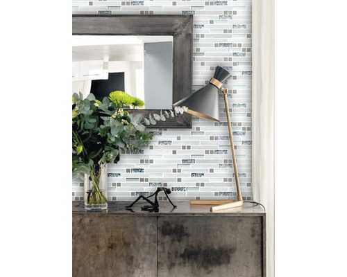 Nástenná dekorácia s mozaikovými dlaždicami v modernom štýle so zrkadlom a lampou na skrinke.