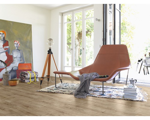 Svetlá miestnosť s drevenou podlahou, kreslom, lampou a maľbou