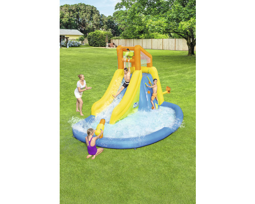 Nafukovacia vodná šmýkačka s bazénom a hrajúcimi sa deťmi v záhrade