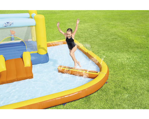Nafukovací skákací hrad s bazénom na záhrade s hrajúcim sa dieťaťom