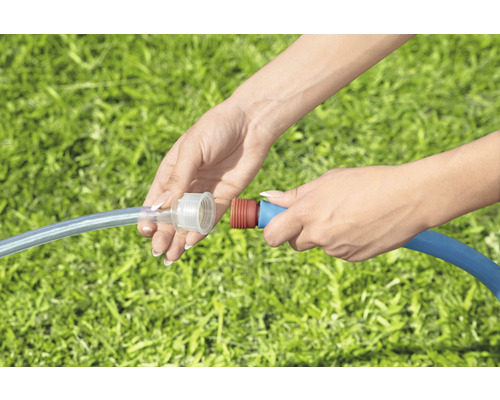 Osoba spája dve záhradné hadice pomocou hadicovej spojky.