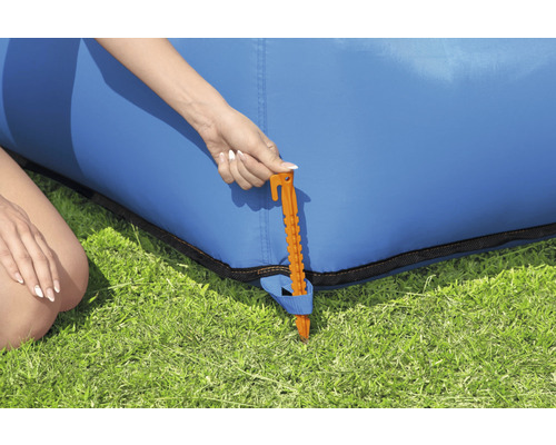 Detailný pohľad na zemný kolík na upevnenie modrej nafukovacej pohovky v záhrade.