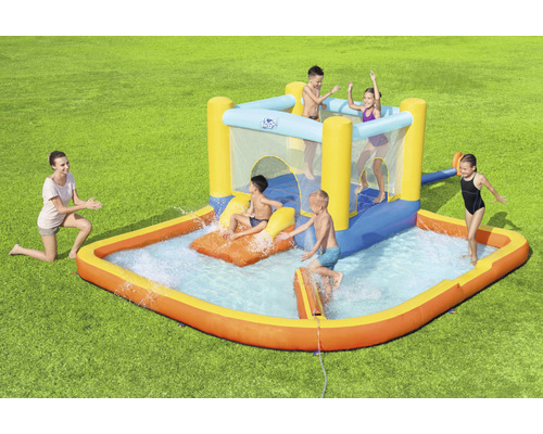 Nafukovací skákací hrad s vodnou šmykľavkou a detským bazénom v záhrade s hrajúcimi sa deťmi