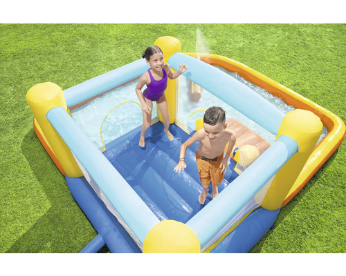 Nafukovací skákací hrad s bazénom a dvoma deťmi v záhrade.