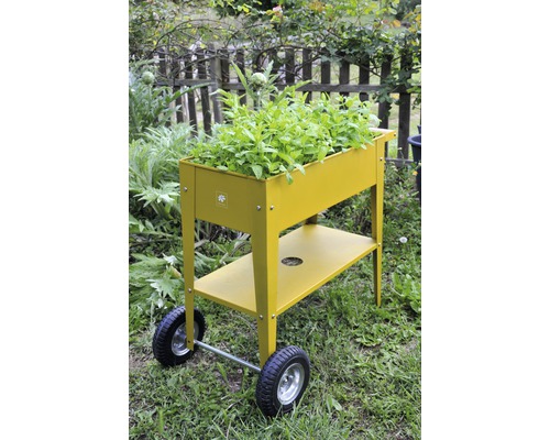 Kovový vyvýšený záhon s kolieskami a úložnou plochou v záhrade