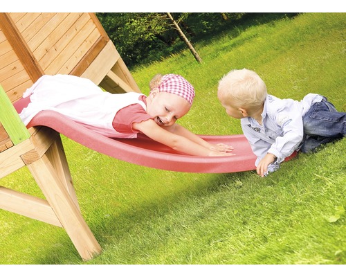 Dve deti sa hrajú na drevenej šmýkačke v záhrade.