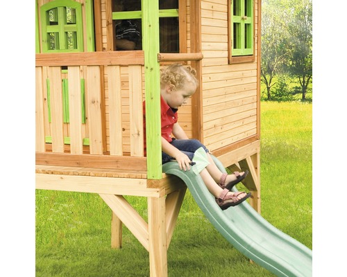 Dieťa na šmýkačke dreveného hracieho domčeka v záhrade.