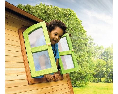 Chlapec sa pozerá z okna dreveného domčeka na hranie