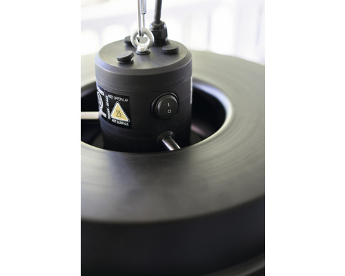 Detailný záber vrchnej časti ohrievača s vypínačom a varovaním pred horúcim povrchom