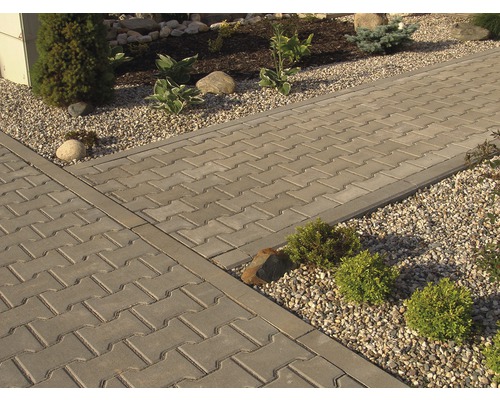 Dláždená cesta s obrubníkmi a štrkom vedľa záhrady