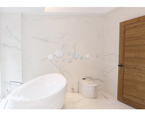 Moderná kúpeľňa s voľne stojacou vaňou, toaletou a okrúhlymi zrkadlami ako dekorácia