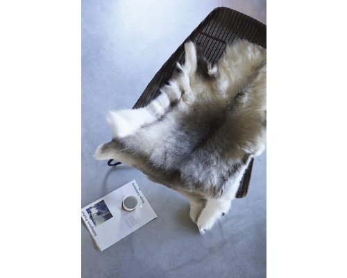 Dekoračná kožušina na stoličke, pod ňou časopis a šálka