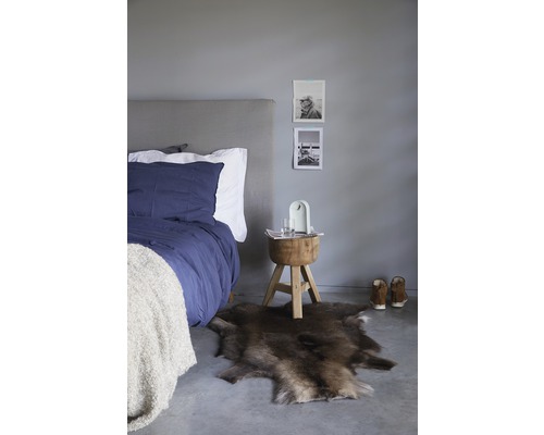 Spálňa s posteľou, kožušinovým kobercom a drevenou stoličkou