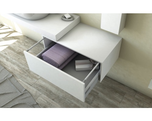 Biela skrinka pod umývadlo s otvorenou zásuvkou, vyplnená uterákmi a darčekovou krabičkou