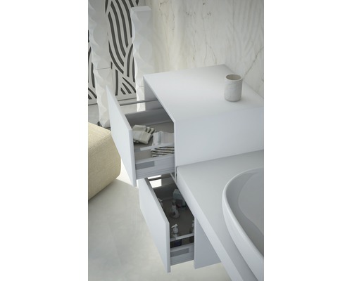 Detailný záber bielej skrinky pod umývadlo s dvomi otvorenými zásuvkami, ktoré ukazujú uteráky a produkty starostlivosti.