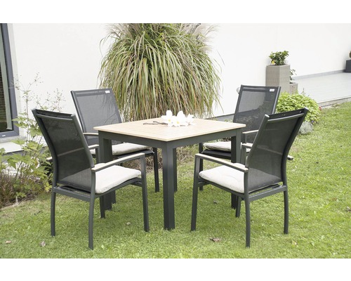 Štvorcový záhradný stôl so štyrmi stoličkami a podsedákmi na trávniku