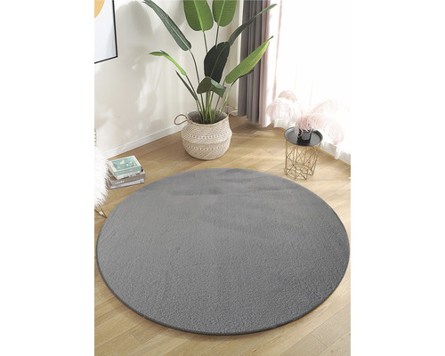 Okrúhly sivý koberec vo svetlej miestnosti