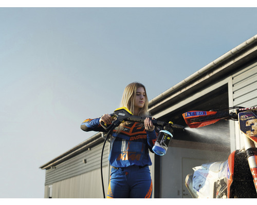 Žena čistí motorku pomocou vysokotlakového čističa.