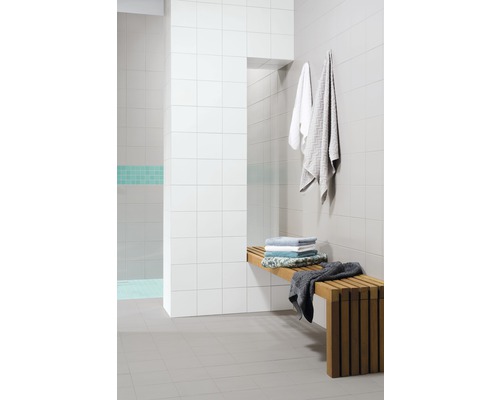 Obkladaný sprchovací kút s drevenými lavicami a uterákmi