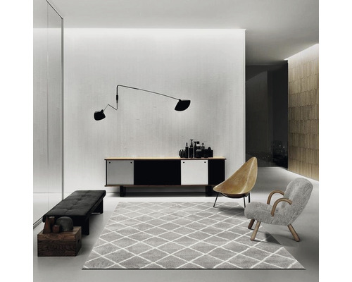 Obývacia izba s príborníkom, kobercom, kreslami a nástennou lampou